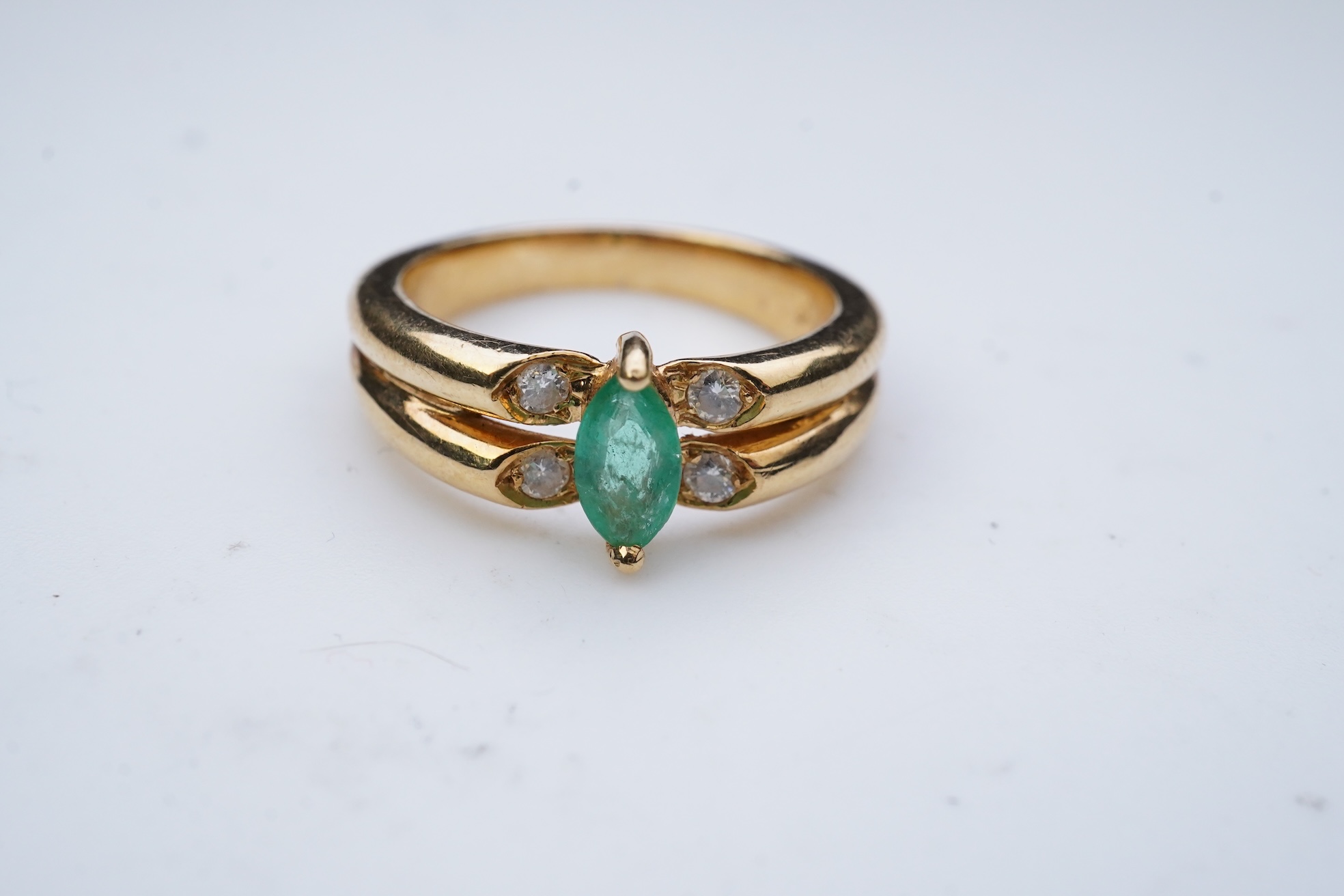 An emerald and diamond ring